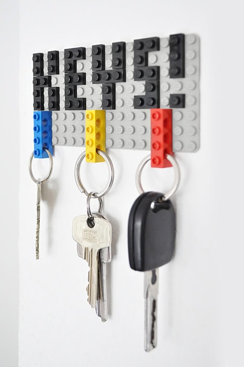 Colorful LEGO-style wall key holder with three hooks holding keys and a car key, designed for organizing keys in a playful and modern style.