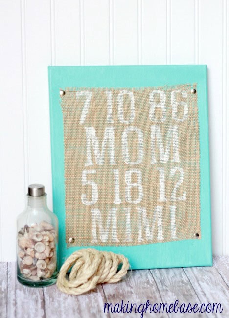 Decorative wall hanging with birthstones and names, featuring a turquoise frame, shells in a glass jar, and a rope, perfect for personalized home decor.