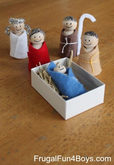 Cute handmade nativity scene with felt figures representing Mary, Joseph, baby Jesus, and angels, on a wooden surface, perfect for holiday decorations and Christmas storytelling.