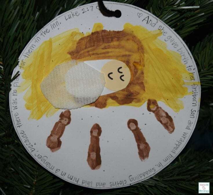 Colorful handmade nativity scene craft with a paper angel, brown figures, and a circular message about Jesus' birth, created for Christmas decoration and religious celebration.