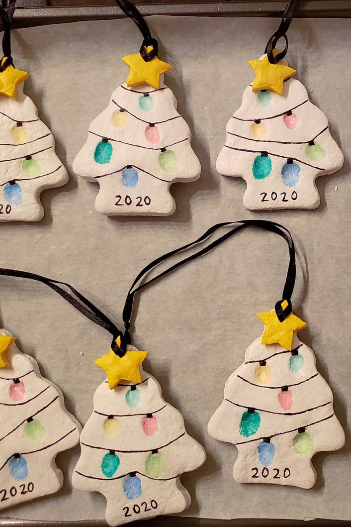 Set of handmade ceramic Christmas tree ornaments decorated with colorful lights, yellow stars on top, and '2020' written at the bottom, perfect for holiday decor.