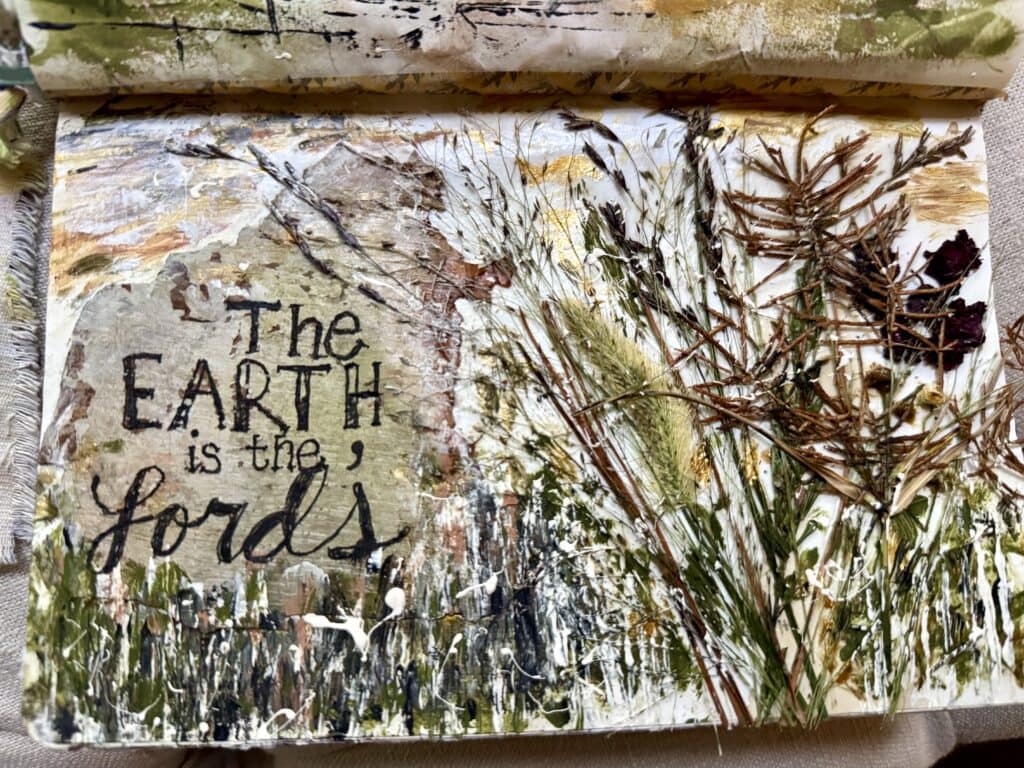 Decorative wall art featuring a quote about the earth and natural elements like leaves and twigs, emphasizing eco-friendly and rustic decor themes.