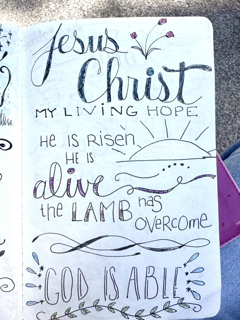 Handwritten Christian quote about Jesus Christ, hope, and faith with decorative elements like flowers, sun, and waves, in a sketchbook for spiritual inspiration.