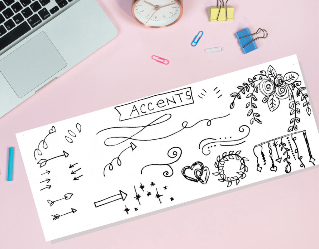 Black and white hand-drawn accents, arrows, hearts, and floral doodles on a white paper sheet, with office supplies and a pink background, for creative projects and design inspiration.