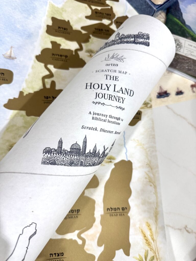 A rolled map labeled The Holy Land Journey with biblical locations and illustrations, featuring a detailed street-like drawing of landmarks and a ship on blue sea accents.