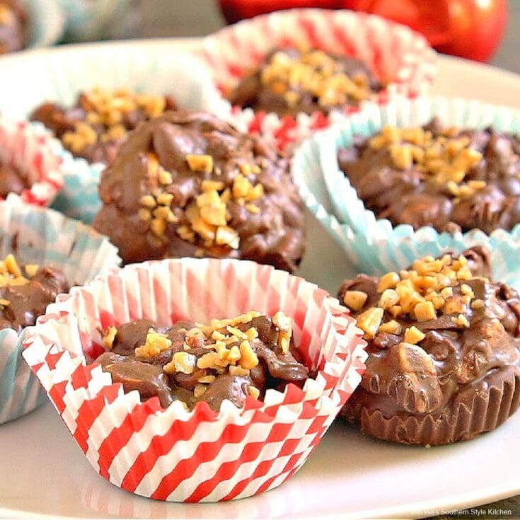 Delicious chocolate peanut butter cups in colorful paper liners topped with chopped nuts, arranged on a white plate.