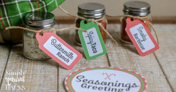 Three labeled seasoning jars with buttermilk ranch, spinach, and smoky barbecue tags, plus a decorative Seasons Greetings card on a rustic wooden surface.